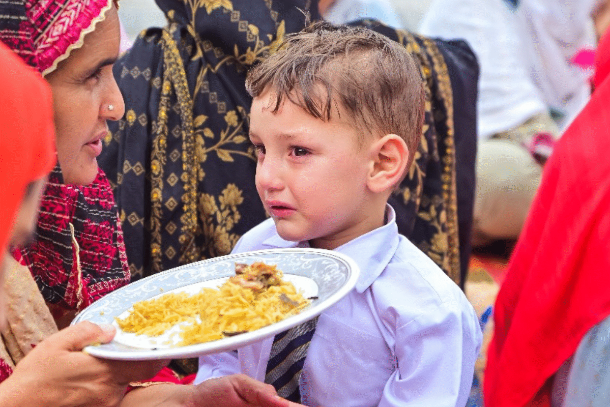 hungry child eating rice food in Azad Kashmir after finishing school, food poverty.